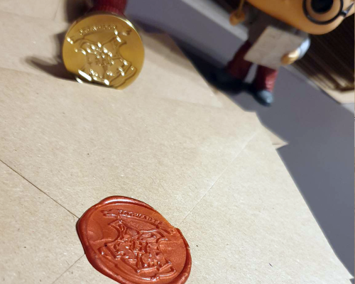 Fermeture des enveloppes kraft pour les faire parts Harry Potter avec le sceau en cire poudlard
